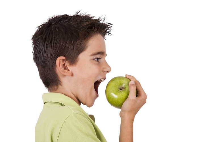 Niño comiendo manzana
